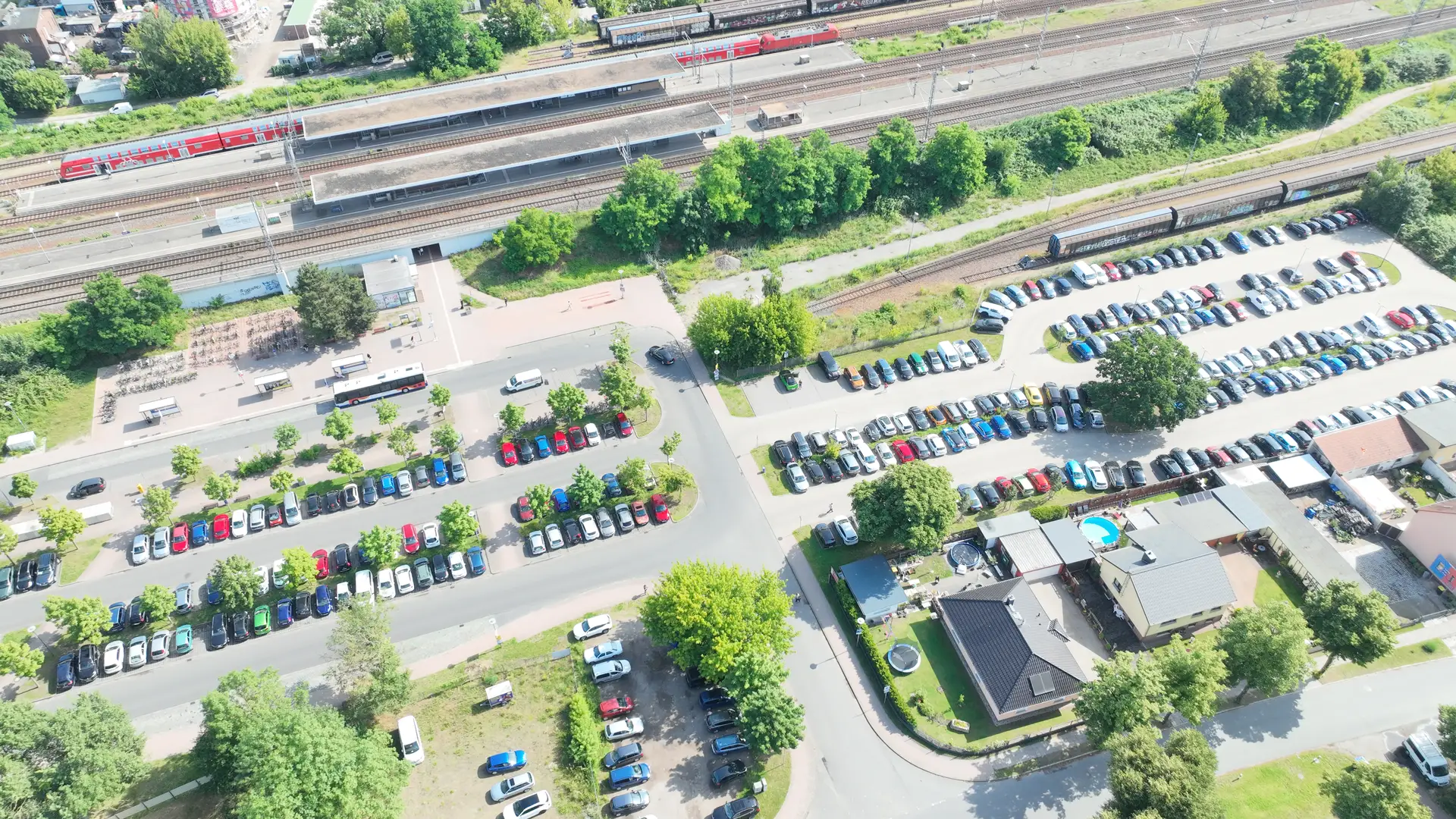 Foto des Bahnhofs Nauen mit angrenzenden Parkflächen, aufgenommen aus einer erhöhten Perspektive.